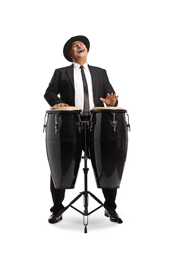 Cheerful mature man playing conga drums and singing isolated on white background