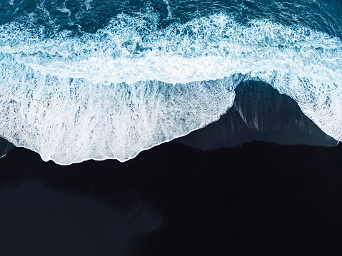 Top down view of waves crashing on the black sands beaches of Selheimasandur in Southern Iceland. High quality photo