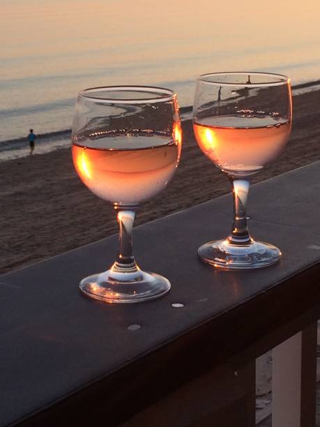 Two wine glasses and people running on the beach