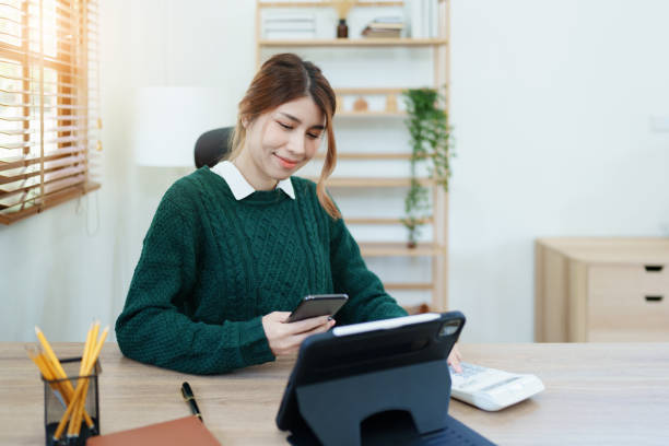 business owner or Asian male marketers are using smart phone and tablet computer in office work