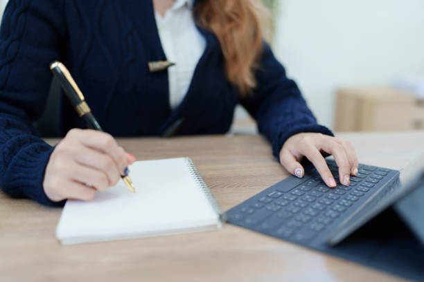 istock Portrait of a young Asian man showing a smiling face as she uses his notebook, tablet computer and financial documents on her desk in the early morning hours 1447270077