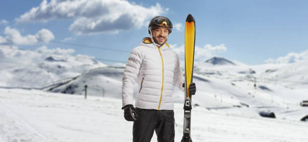istock Young man with ski and equipment posing on a ski resort 1447273431