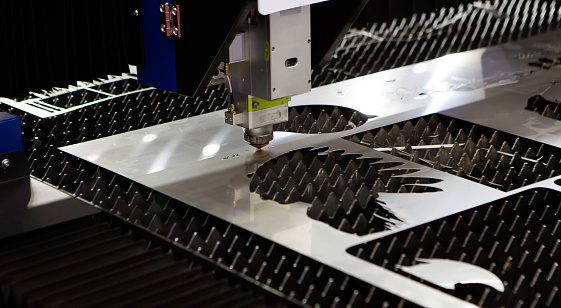 CNC laser cutting machine cutting metal sheet in factory. Industrial manufacture.