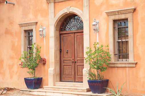 Vibrant color single window and blinds on orange color wall in Nice city, France.