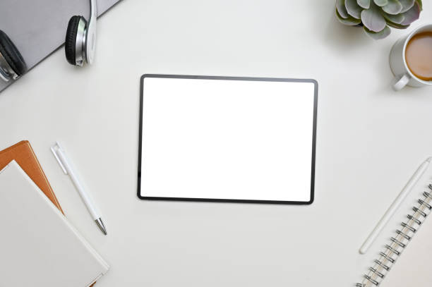 istock Top view of white modern workspace with blank screen tablet with books and stationeries 1447291555
