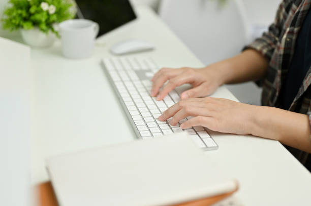 istock Close up view of young woman typing on keyboard while working in her office. 1447291602