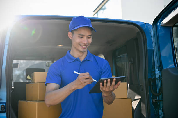 istock Young delivery man checking orders with tablet before handing package to customers 1447292222