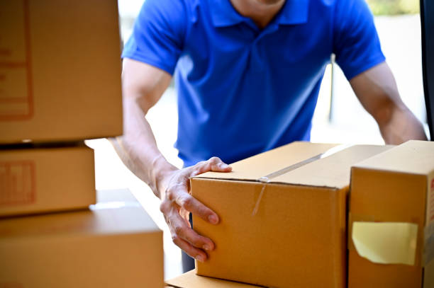 Close up view of delivery man organizing packages before handing package to customers stock photo