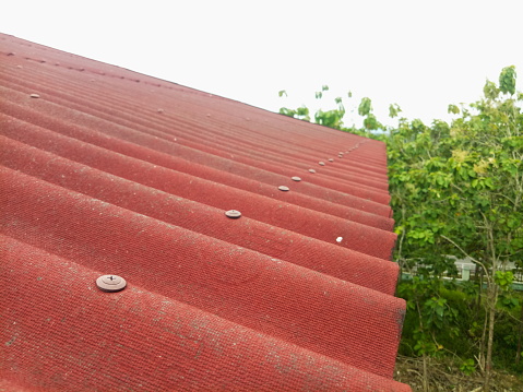 Closeup of red roof cover. Tiled roof with sky background