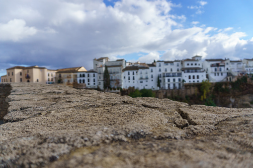 view of the buildings on the edge of the cliff of tajo de ronda , malaga spain with cloudy sky