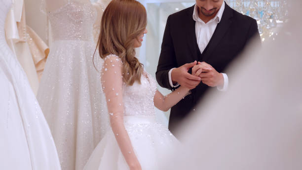 istock Young Asian couple trying on wedding dresses in wedding studio. 1447300232