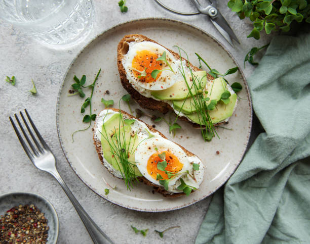 istock Bread toast, boiled eggs, avocado slice, microgreens on a plate 1447300442