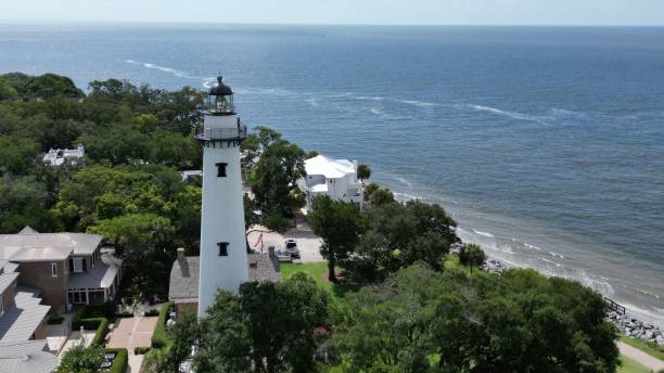 Aerial view of the St. Simons Island lighthouse and a beautiful beach on a sunny day An aerial view of the St. Simons Island lighthouse and a beautiful beach on a sunny day saint simons island photos stock pictures, royalty-free photos & images