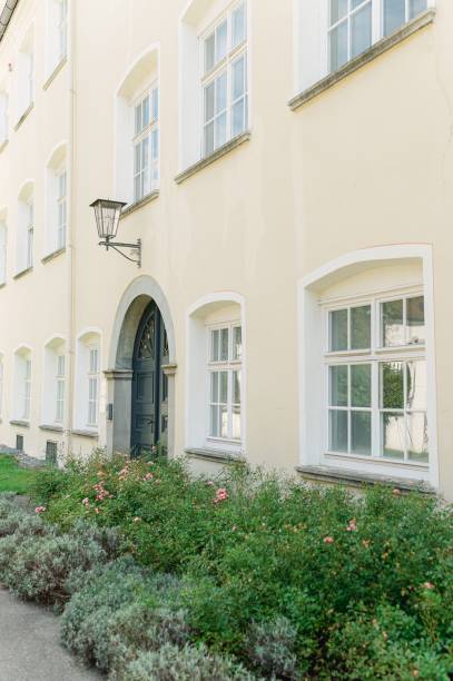 istock Vertical shot of white building surrounded by growing shrubs in Germany 1447308630
