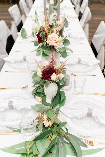 istock Vertical shot of flowers in small vases on a wedding table 1447308664