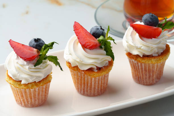 istock Cupcakes with strawberries and cream on white table 1447309378