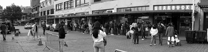Seattle, United States – July 05, 2022: A panoramic grayscale shot of people in front of the first star bucks in Seattle, Washington