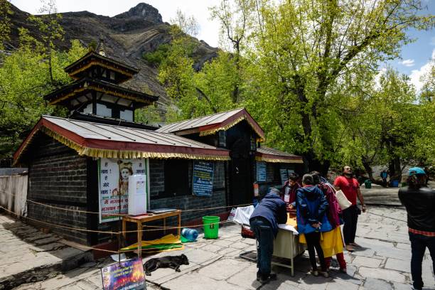 buddhistische pilgergläubige in traditioneller kleidung im heiligen muktinath tempel im himalaya - muktinath stock-fotos und bilder