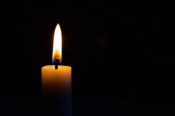 istock Candle with fire on it isolated on a black background 1447313510