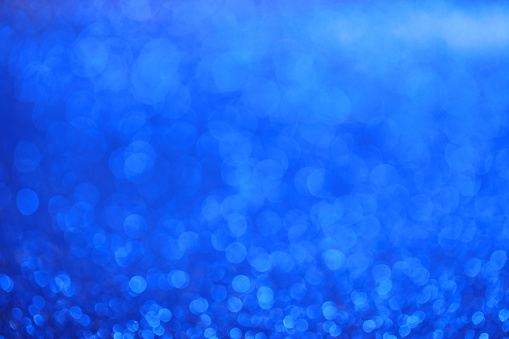 Defocused sparkling background in blue tones. Beautiful bokeh lights.