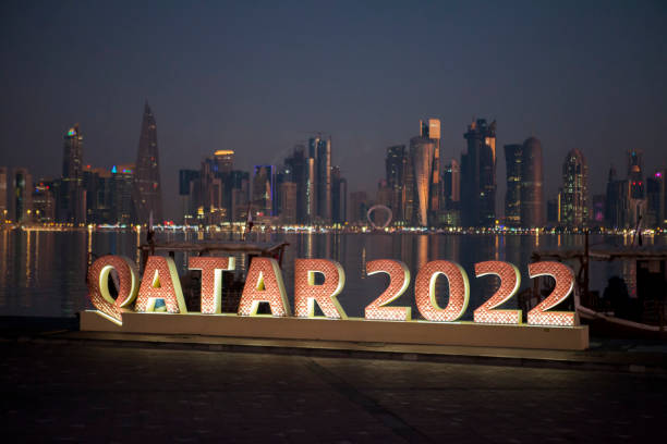 duży podświetlany znak qatar 2022 na zakręcie corniche, z dzielnicą biznesową west bay w tle - capital letter luxury blue image zdjęcia i obrazy z banku zdjęć