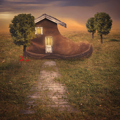 Cute cozy fantasy shoe house in a country field in the sunset.