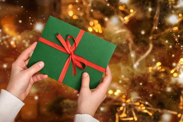 Christmas Gift Certificate or New Year Gift Envelope in Girls hands