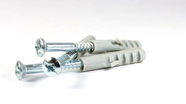 istock Closeup of metallic dowels with screws on a white background 1447327556