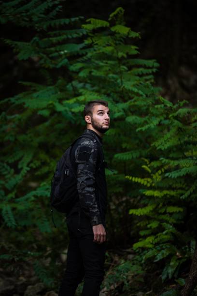 istock Caucasian man in a black military uniform in a forest 1447329352