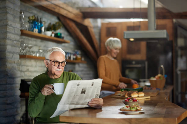 istock Senior man drinking coffee and reading newspapers at home. 1447339304