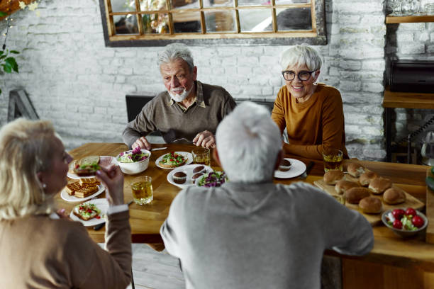 istock Happy mature couples enjoying in conversation during a meal at dining table. 1447340030