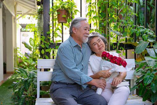 Senior couple travel on urban street. They are sitting in the garden. Active senior lifestyle.