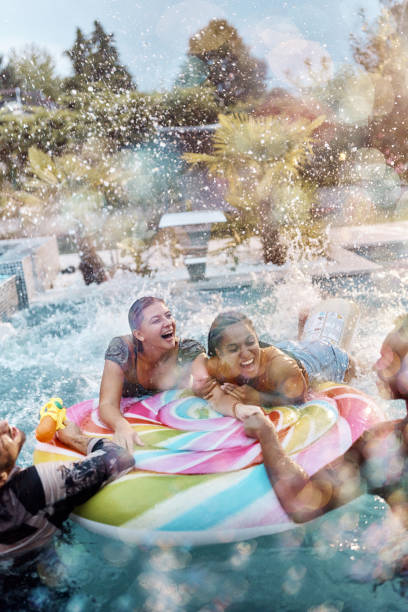 istock Cheerful couples having fun on a pool raft at the swimming pool. 1447341746