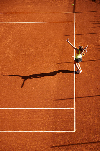 Tennis player playing on a clay tennis court.