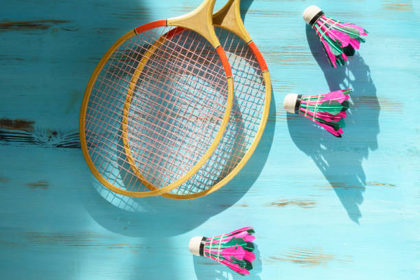 istock Shuttlecocks and badminton rackets on blue wooden background. Flat lay 1447342861