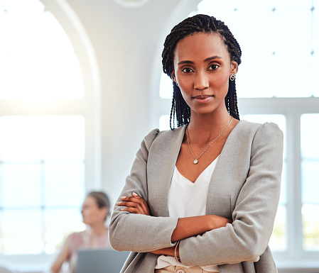 Retrato, mujer afroamericana y líder de pie en la oficina confiados, relajados y felices por el éxito de los negocios. Orgullosa, emprendedora y dama negra cruzada de brazos, motivación y startup photo