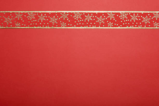 Silver snowflakes laid out in one straight line / row on a plain blue background