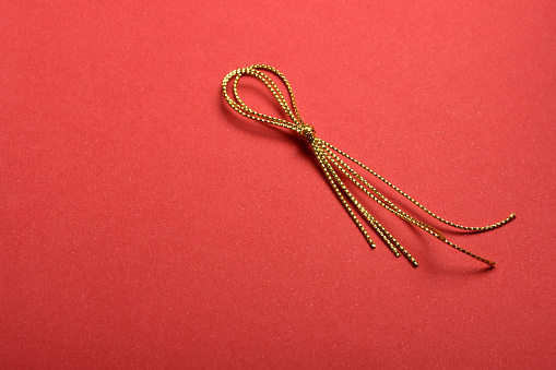 Gold thread ribbon on the red background with copy space
