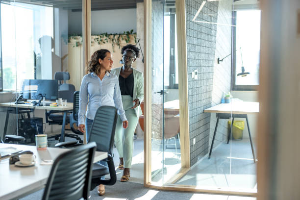istock Two Multiracial Colleagues Walking Out From A Cubicle While Having A Small Talk 1447347205