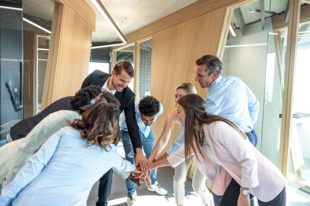 istock Multicultural Marketing Group Smiling And Joining Their Hands To The Center 1447347216