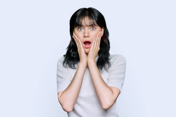 istock Young shocked woman looking at camera on white background 1447347755