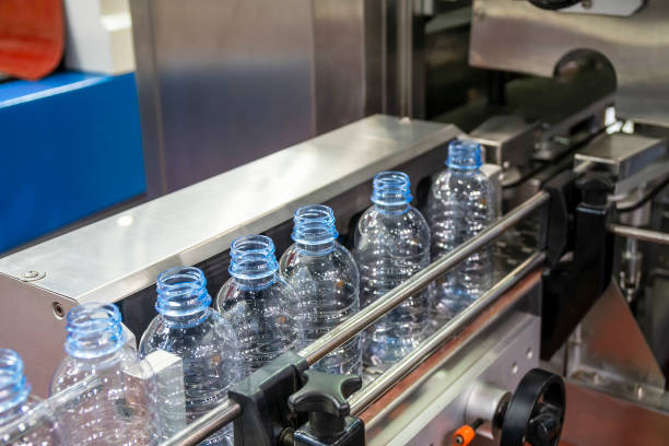 充填工程用コンベヤベルト上の空の飲料水ボトルのクローズアップシーン。 - bottling plant bottle filling production line ストックフォトと画像