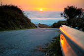 Asphalt mountain road high above the clouds during sunset. Location: Monchique in Portugal.