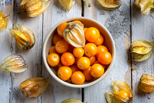 Bowl of mandarins, cones and spruce branches on rustic wooden table