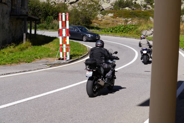 Motorcyclists way up to Swiss mountain pass Grimselpass at hamlet Gletsch, Canton Valais, on a sunny lates summer noon. Photo taken September 12th, 2022, Gletsch, Switzerland.