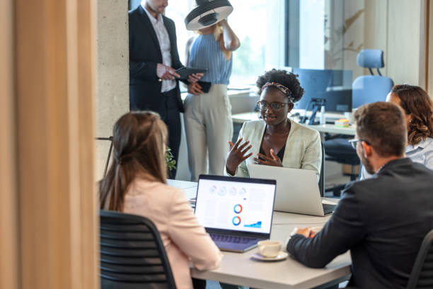 istock Dark-Skinned Young Female Manager Explaining A Project To Her Coworkers 1447352209