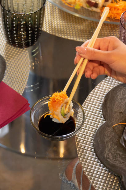 istock Sushi on the table with hand and chopsticks 1447352439