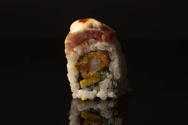 istock Sushi uramaki sashimi on a black background 1447352530