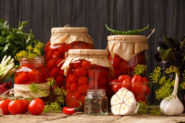 istock Jars with canned tomatoes on wooden background 1447352574