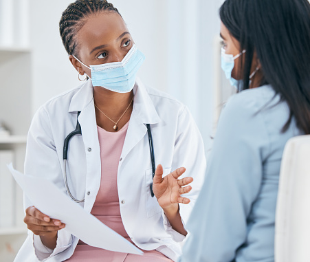 Doctor consulting patient, medical mask and communication  healthcare wellness. Professional clinic nurse, surgery advice conversation and health insurance paper checklist or consultation in room